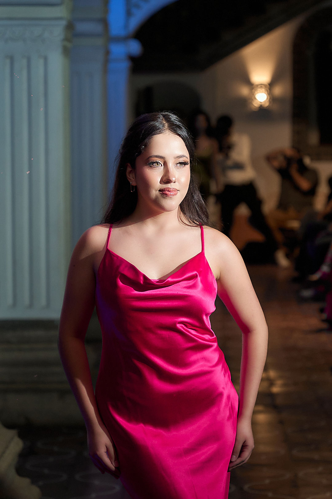 Modelo en la pasarela de Antigua Guatemala con vestido de satén fucsia